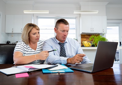 Photo of a couple by a laptop